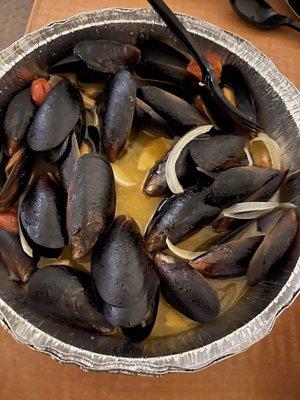 Mussels soaked in butter, tomato's, onions, along with whole cloves of garlic.