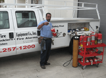 Technician performing annual fire extinguisher maintenance.