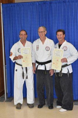 Mr. Brown (r) receives his 7th Dan certificate of rank from Mr. Walliser (c) at the Koinonia gathering in the spring of 2017.