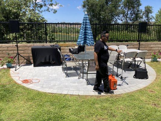 Moises setting up the speakers, microphone stands, and soundboard.