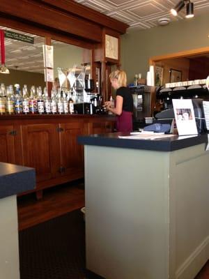 Barista making one of their specialties "Affogato".  Hot espresso poured over dense ice cream.