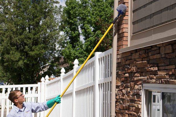 Technician removing spder webs from customers home