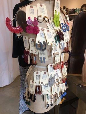 An eclectic array of earrings adorn this mannequin display.