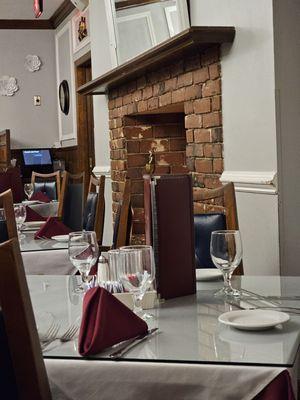 A table set up  next to the fireplace.