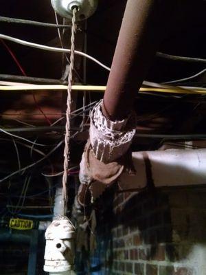 Asbestos pipe insulation in a basement in poor condition.