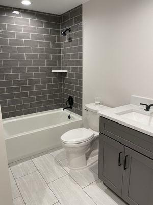 Bathroom upgrade. New wall and floor tile; painted walls; new vanity and hardware. (After)