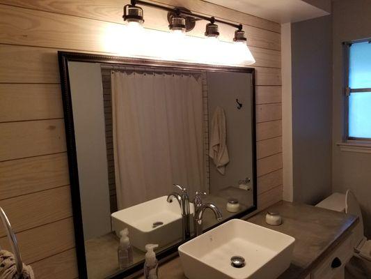 Shiplap backing, customer framed mirror, Edison light, vessel sink, and concrete countertops