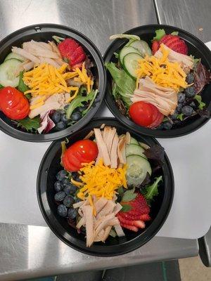 These are our deluxe turkey salads to include mixed greens, tomatoes, cucumbers, strawberries, blueberries, and cheese.