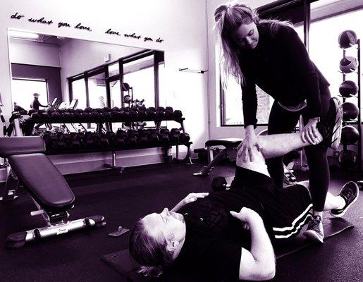 Trainer Kilee Jansen stretching a client after his workout.