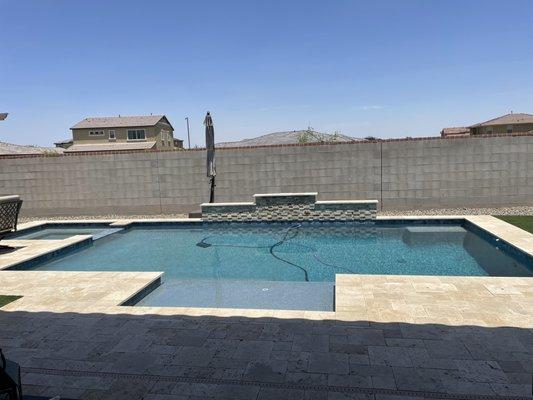 Custom pool with waterfall and travertine decking