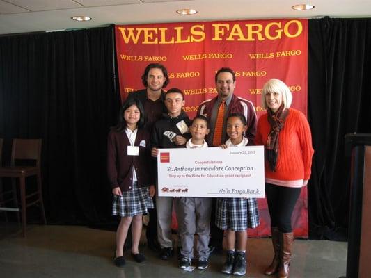 Principal Miguel Martinez with several students and Brandon Crawford from the S.F. Giants receiving a scholarship for our school