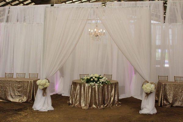 Sweet heart table with drapery ad chandelier.