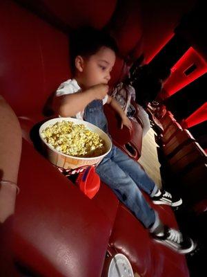 My tot enjoying his popcorn in a big, comfy recliner