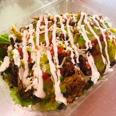 A taste of both worlds! A fresh bed of romain lettuce with a layer of savory carnitas, cheese, sourcream, and flavorful salsa!