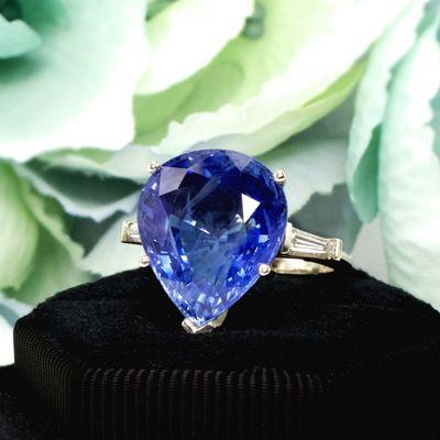 An incredible 12.70 carat GIA Ceylon sapphire is prong set in a simple white gold setting, subtly accented by tapered baguette diamonds.