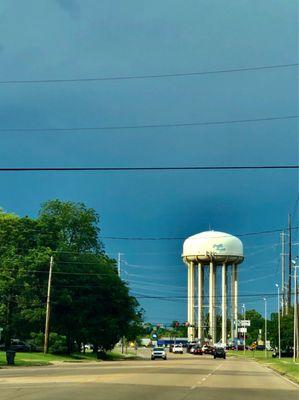 Heavy rain behind the water tower. Sun in front.