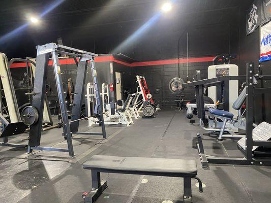 Back of gym with the various racks and smith machines.