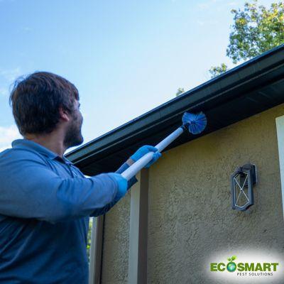 Pest Control Technician performing exterior treatment.