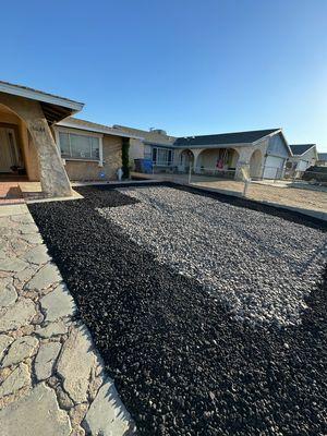 "Modernize your front yard with a striking mix of black and gray decorative rocks for a clean, low-maintenance look."