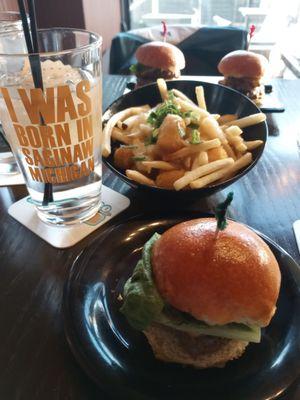 Cowbell slider in front, poutine with fries & tater tots, and 2 More Cowbell sliders in background.