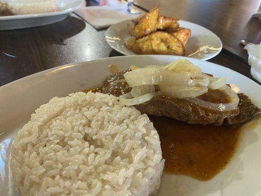 Bistec encebollado con arroz blanco