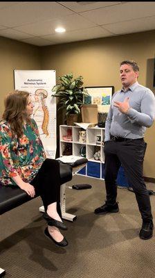 Dr. Jeff is going over some exercise our client to do to help prevent her chronic migraines in between appointments