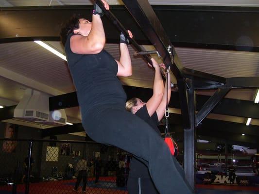 Rachel and Rebecca do pullups at during an xfit class.