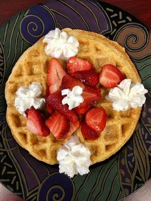 Homemade Waffle with fresh strawberries and whipped cream.