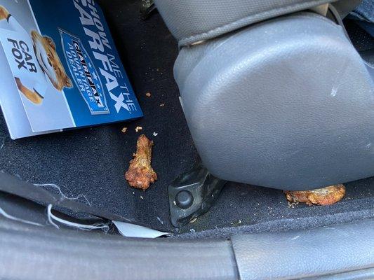 old bitten into chicken wings behind passenger seat