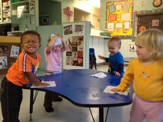 Toddlers delight in doing "big people jobs".  They are cleaning the table after a 'messy" art project.