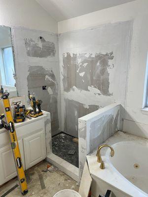 We moved the old shower, including the rotted drywall beneath the tile, and installed cement board. Install anew shower pan and floor tile.