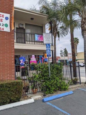 Across from Yum Yum Donuts. Located on a corner with a small parking lot