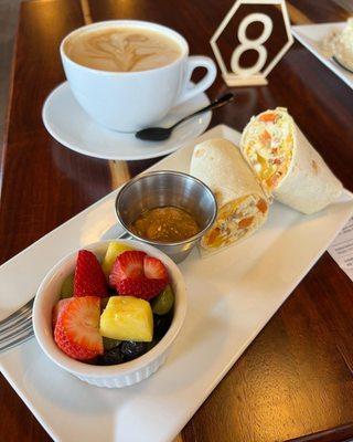 Breakfast burrito with salsa and fruit.