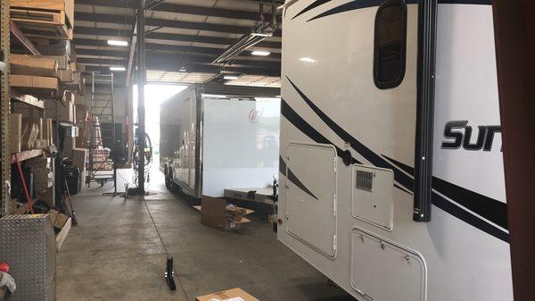 Motorhome and trailer in the shop getting a new receiver and hitch installed.