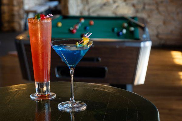 Drinks in game room with pool table, cocktails.