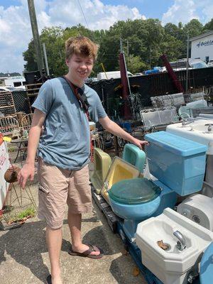 Lots of wacky midcentury bathroom peices outside: toilets and sinks of every color!