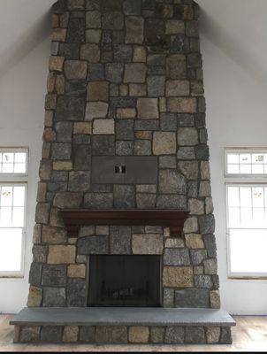 Indoor Natural Stone Veneer Fireplace with Mantle custom built by Long Island 5 Star Masonry & Construction Inc.