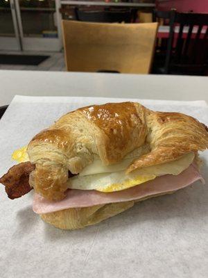 Breakfast croissant with ham egg bacon and cheese sandwich