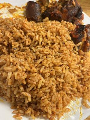 Jollof rice with stewed rice, one piece of meat missing, we were too excited to take a picture and ate first