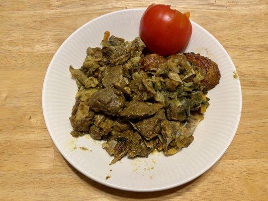 Curried goat, on my own plate at home with a tomato from my garden.