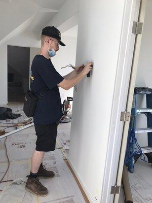 Zach, one of our service technicians, installing the thermostat to finish the job.