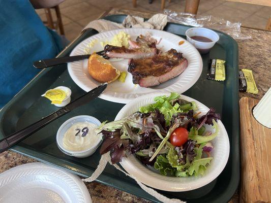 Pork ribs, salad with blue cheese dressing and potato salad.