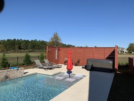 Sun shelf tanning ledge inside pool with a Hot Tub.