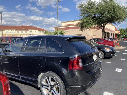 The car shown damaged in the parking lot after service.