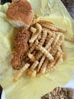 Chicken leg with fries and a roll of