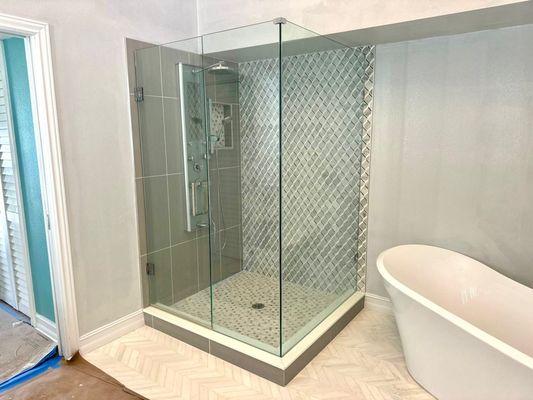 Luxurious bathroom!  Sleek shower enclosure, stunning tile work, and a relaxing soaking tub.