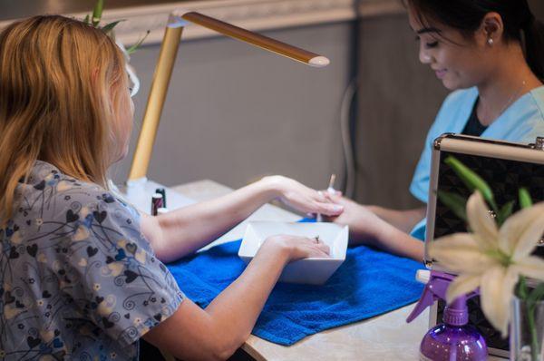 Coworker receiving a manicure.