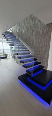 Cantilever stair with glass railing and lighted treads.