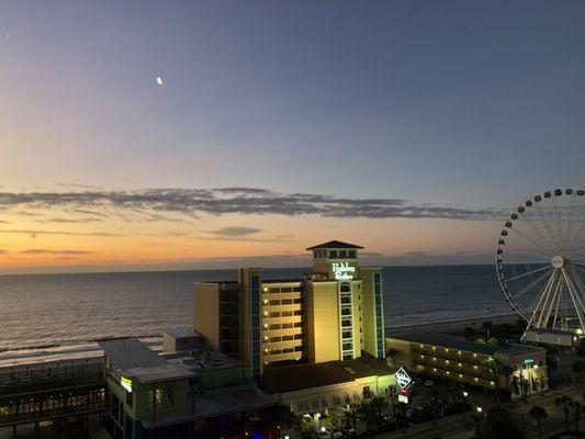 Evening sunset view from balcony with rising moon over ocean