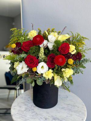 Black velvet box with ranunculus, roses, calla lilies and lisianthus.